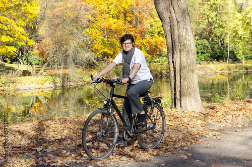 Woman on bicycle in autumn park