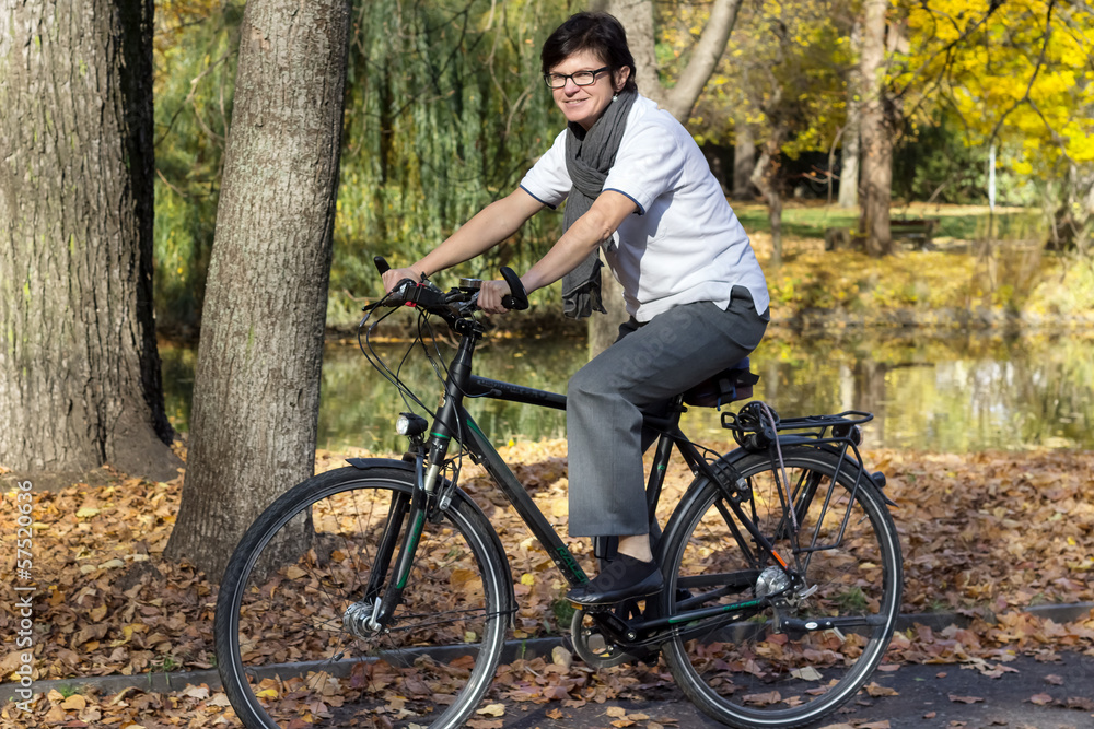 Fototapeta premium Woman on bicycle in autumn park