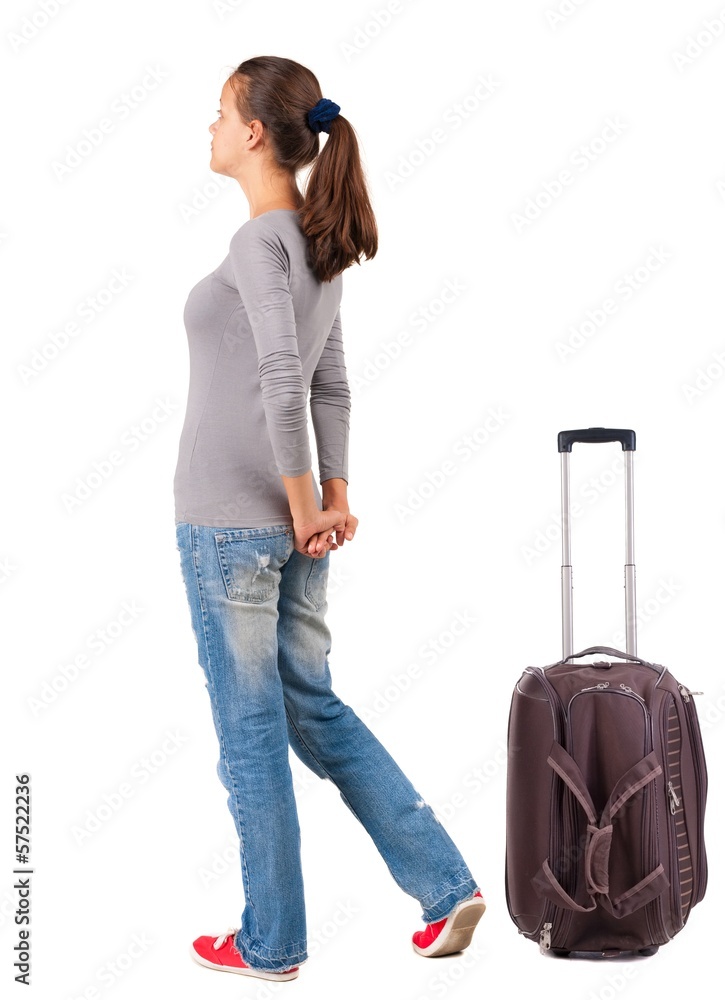 back view of standing young traveling brunette woman with suitca back view of standing young traveling brunette woman with suitca