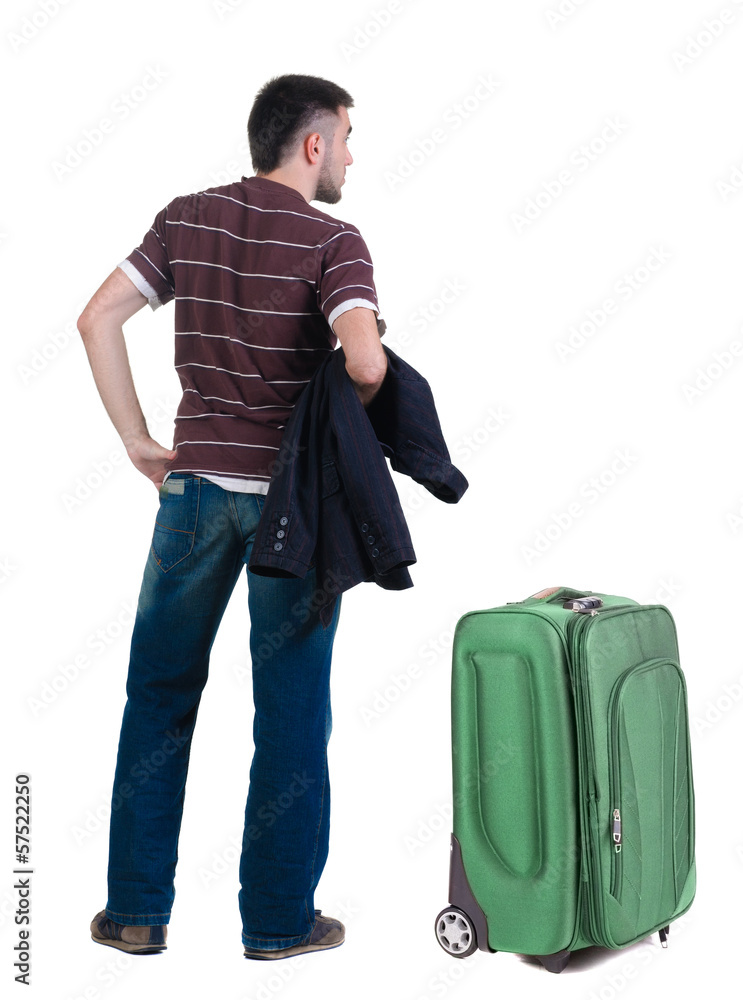 young man traveling with suitcas looks ahead. rear view. young man traveling with suitcas looks ahead. rear view.