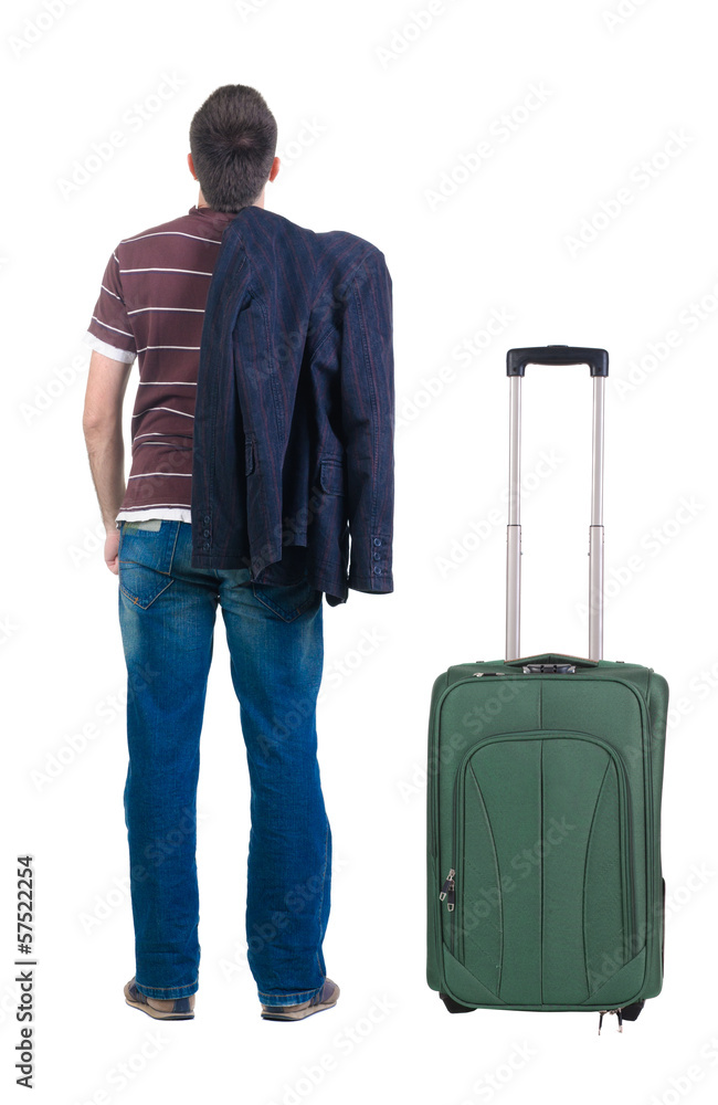 young man traveling with suitcas looks ahead. rear view. young man traveling with suitcas looks ahead. rear view.