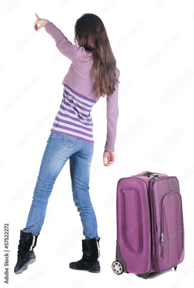 Beautiful young woman traveling with suitcas and pointing at wa Beautiful young woman traveling with suitcas and pointing at wa