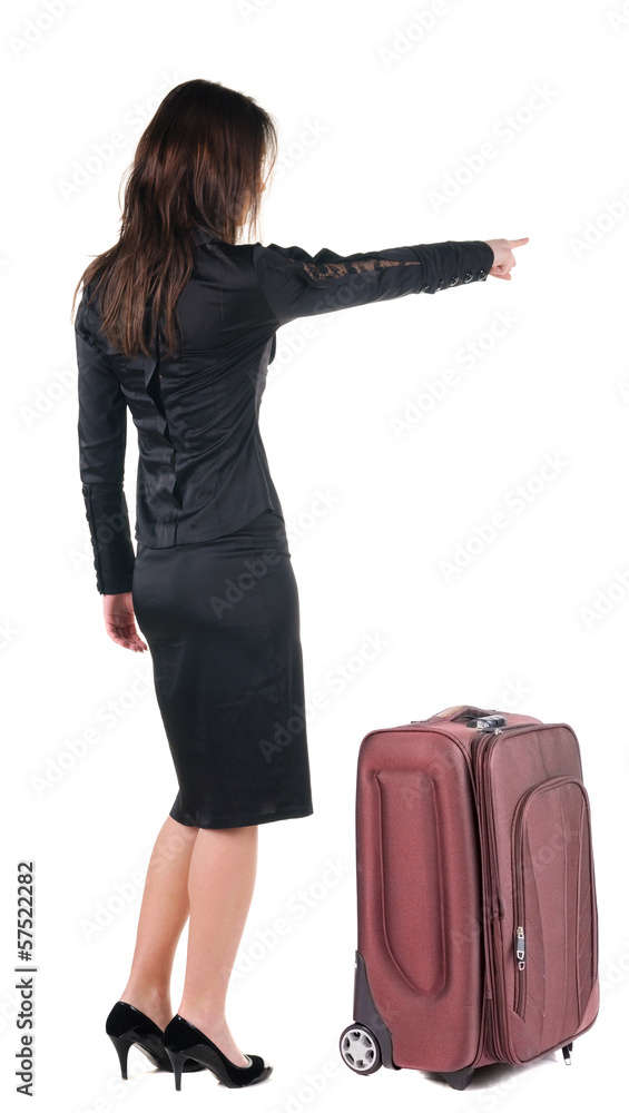 Beautiful young woman traveling with suitcas and pointing at wa Beautiful young woman traveling with suitcas and pointing at wa