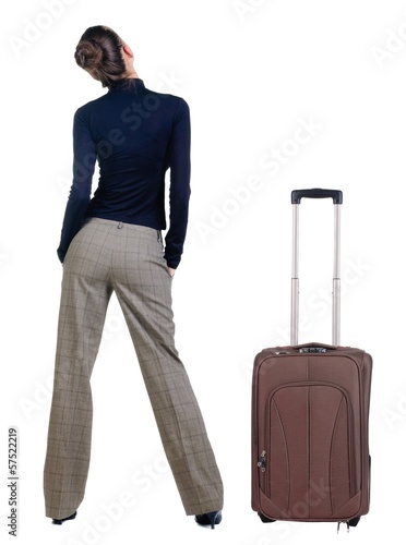 traveling young woman with suitcas looking at wall. photo