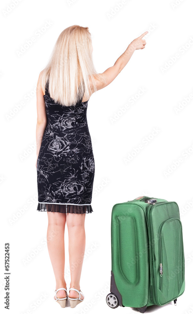 Back view of young brunette woman traveling with suitcas and poi Back view of young brunette woman traveling with suitcas and poi
