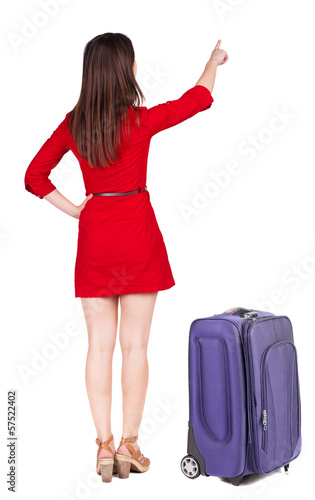 Back view of young brunette woman traveling with suitcas and poi © ghoststone
