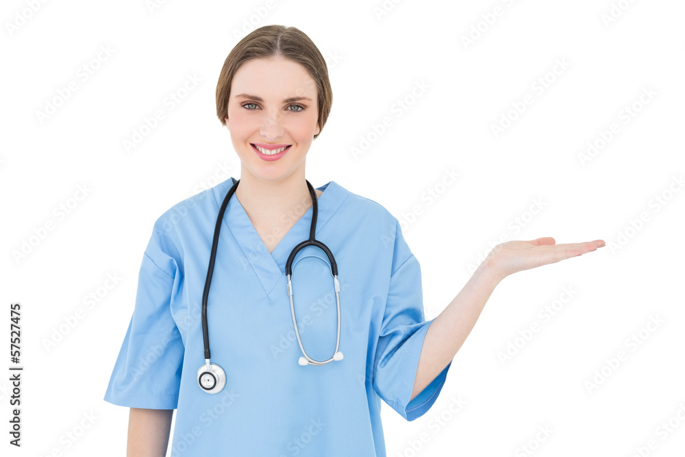 Smiling young woman doctor presenting with her hand Smiling young woman doctor presenting with her hand