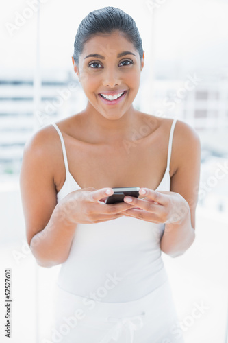 Cheerful toned brunette holding mobile phone Free Download Cheerful toned brunette holding mobile phone - GFXLoad