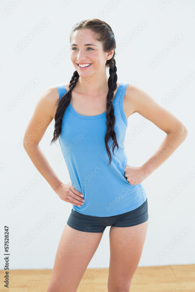 Smiling woman in sportswear and plaits looking away