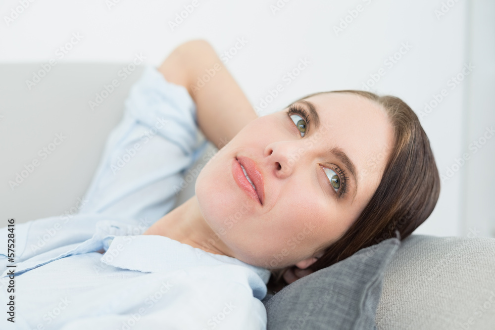 Close-up of a thoughtful woman relaxing on sofa Close-up of a thoughtful woman relaxing on sofa