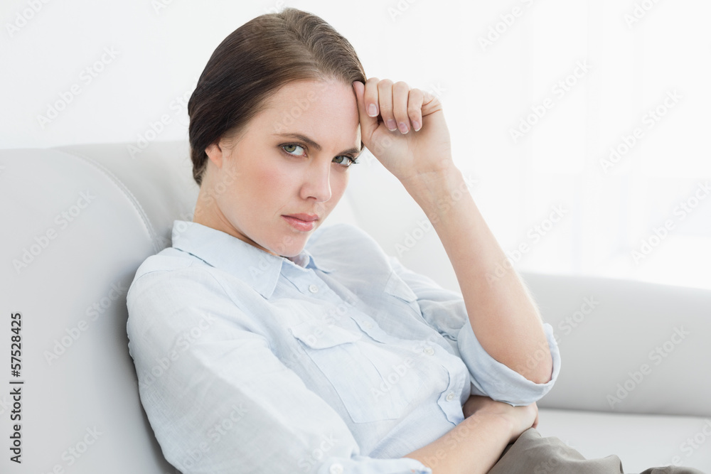 Portrait of a serious well dressed woman sitting on sofa Portrait of a serious well dressed woman sitting on sofa