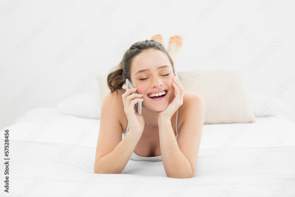 Cheerful casual woman using mobile phone in bed Cheerful casual woman using mobile phone in bed