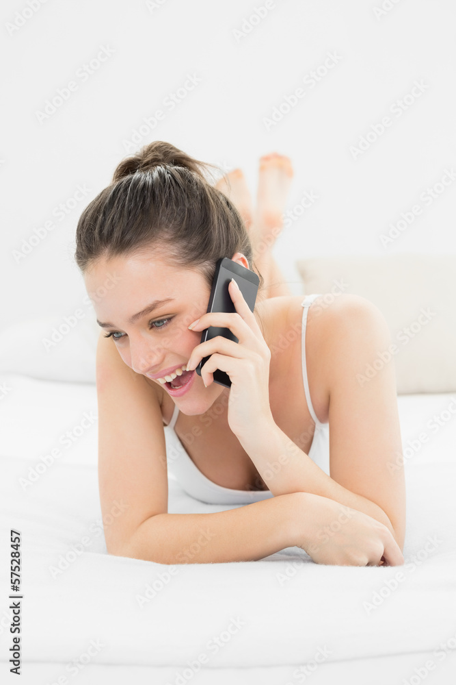 Cheerful casual woman using mobile phone in bed Cheerful casual woman using mobile phone in bed