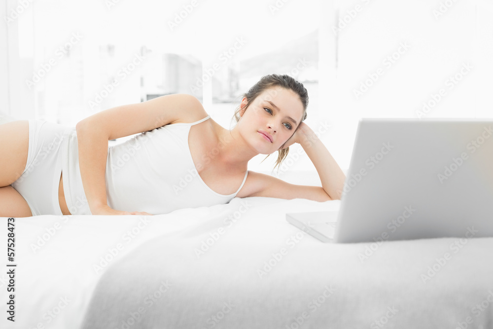 Casual woman looking at laptop in bed Casual woman looking at laptop in bed