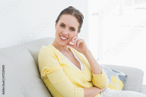 Free Download Smiling relaxed woman sitting on sofa at home - GFXLoad