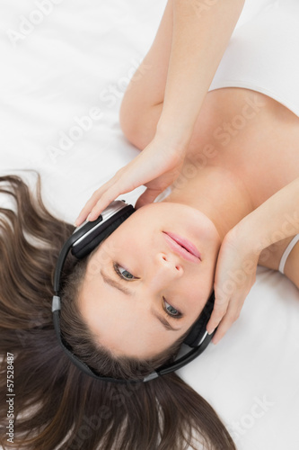 Pretty woman listening to music in bed