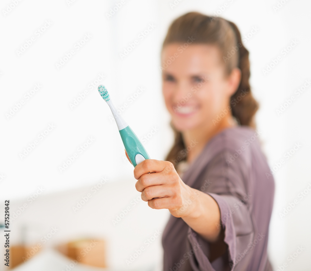 Closeup on toothbrush in hand of young woman Closeup on toothbrush in hand of young woman
