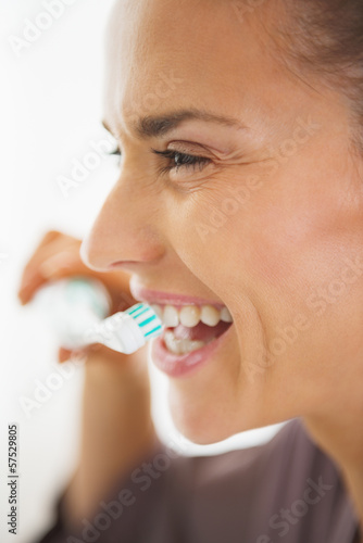 Happy young woman brushing teeth