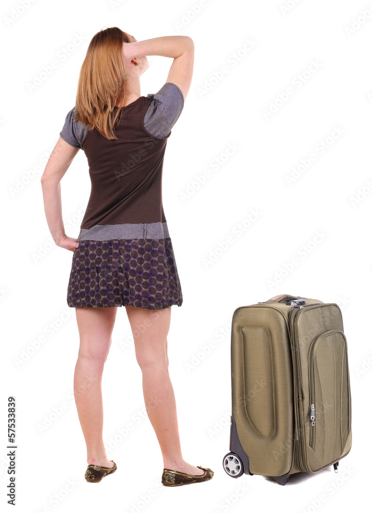 Beautiful young woman traveling with suitcas and looking at wall Beautiful young woman traveling with suitcas and looking at wall