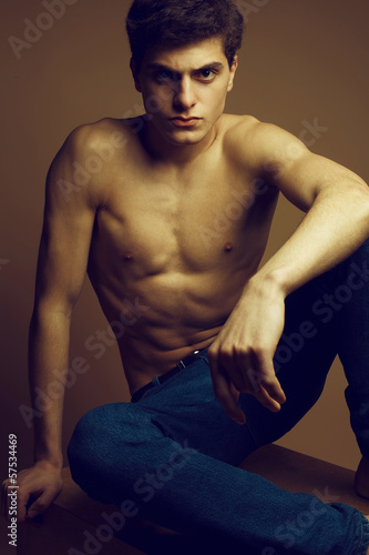 Beautiful (handsome) muscular male model in jeans posing undress