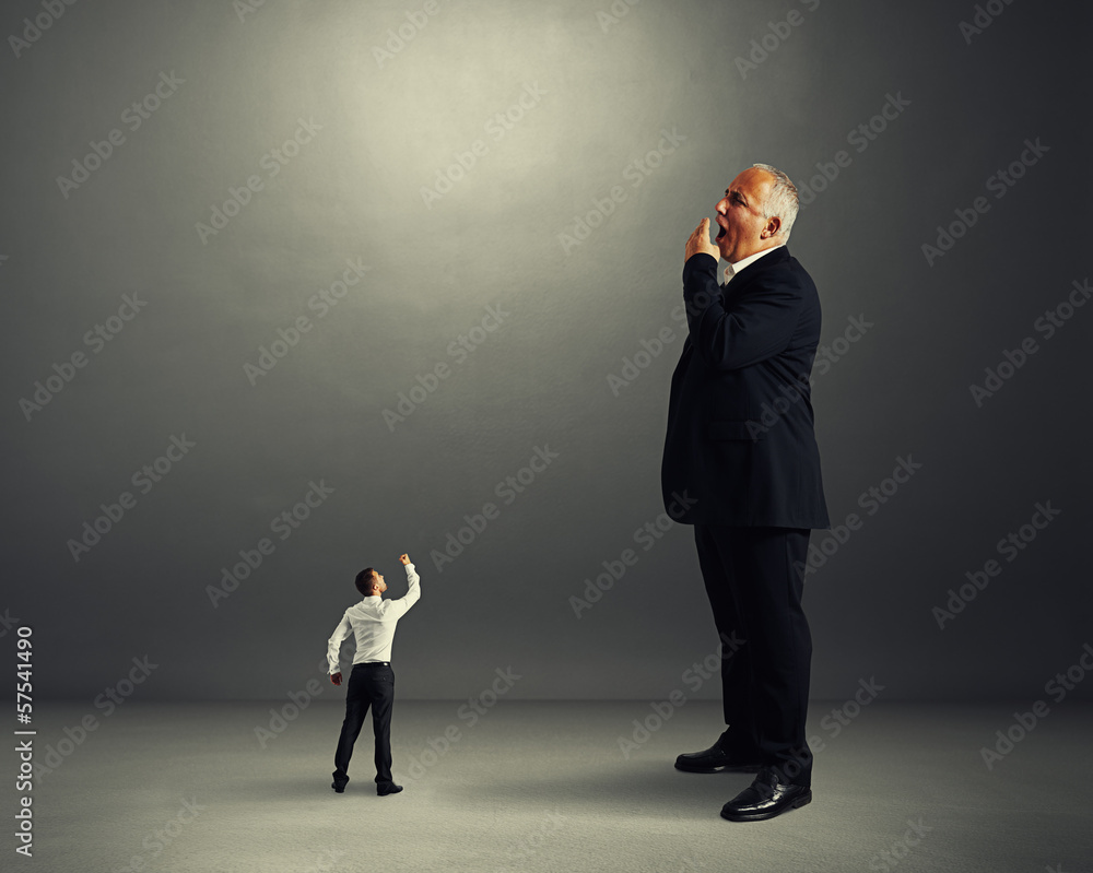 Fototapeta premium man showing fist to big yawning businessman