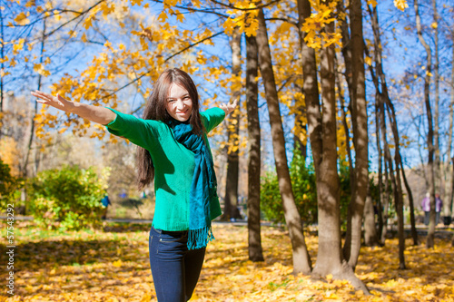 Happy young woman having fun her autumn vacation in park