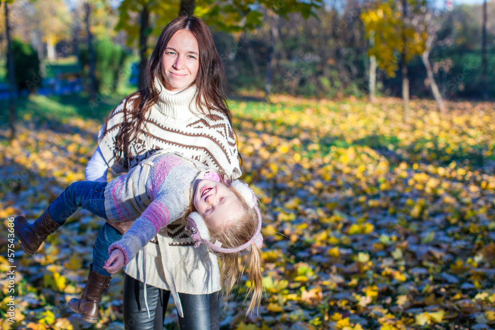 Little adorable girl and young mother in autumn park on sunny Little adorable girl and young mother in autumn park on sunny