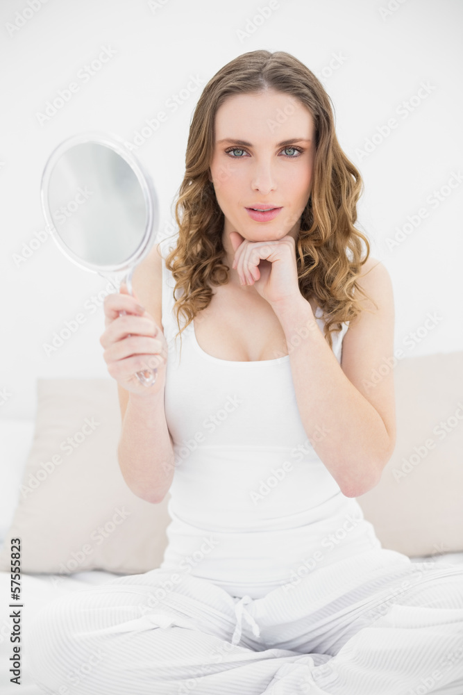 Pretty woman looking into the camera and holding a mirror Pretty woman looking into the camera and holding a mirror