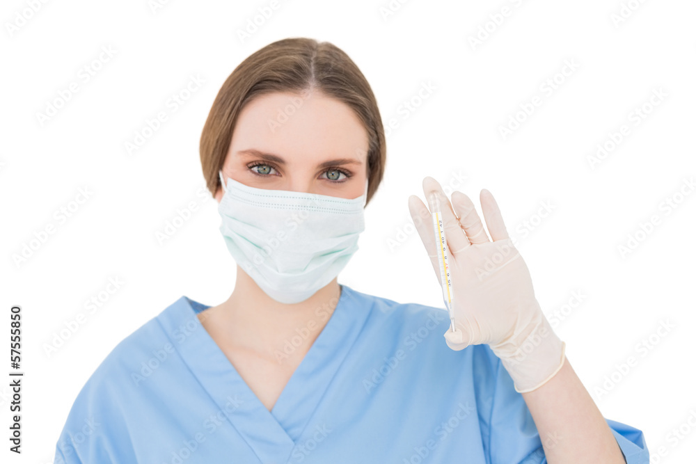 Pretty brunette female doctor holding a thermometer Pretty brunette female doctor holding a thermometer