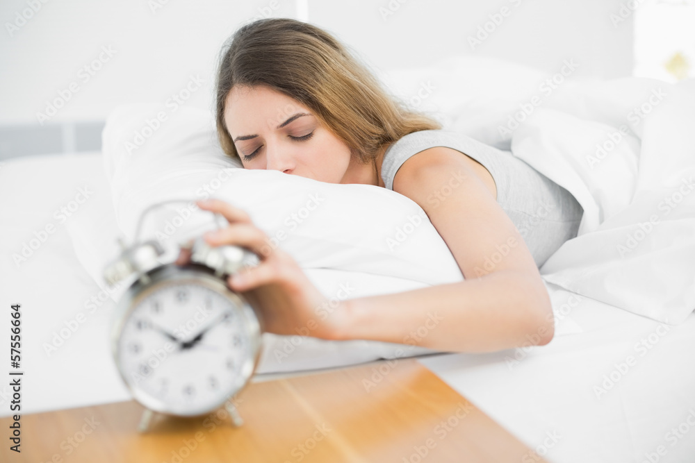 Beautiful peacefeul woman turning off the alarm clock Beautiful peacefeul woman turning off the alarm clock