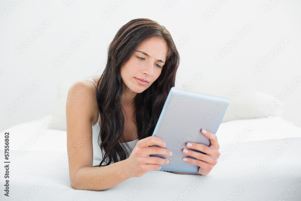 Casual woman using tablet PC in bed Casual woman using tablet PC in bed