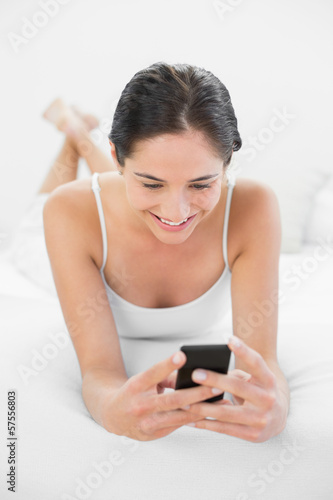 Relaxed woman with mobile phone in bed