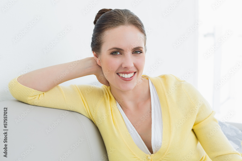 Smiling relaxed woman sitting on sofa at home Smiling relaxed woman sitting on sofa at home