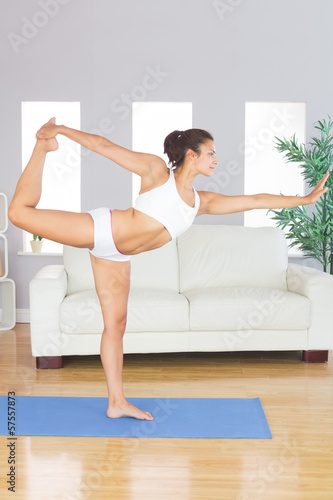 Concentrated slim woman stretching her body in yoga pose