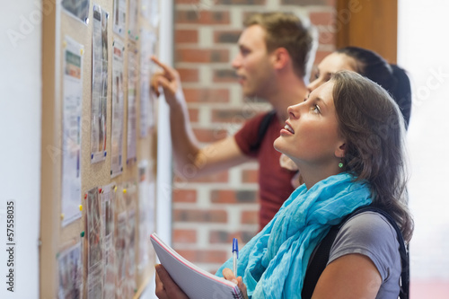 Canvas Print Casual students looking at notice board