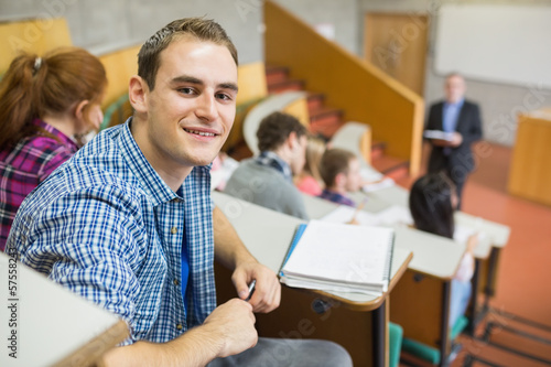 Tableau sur toile Smiling male with students and teacher at lecture hall