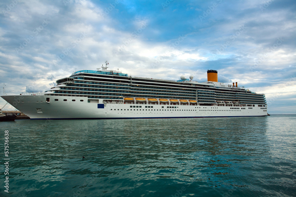 Cruise ship in the sea on the background of blue sky with clouds