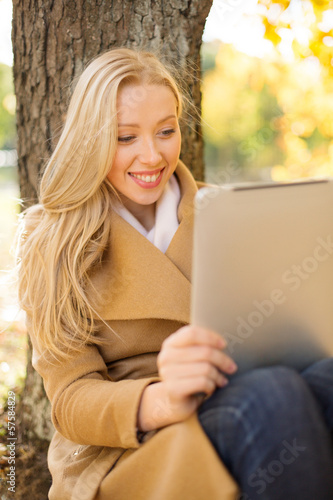 woman with tablet pc in autumn park