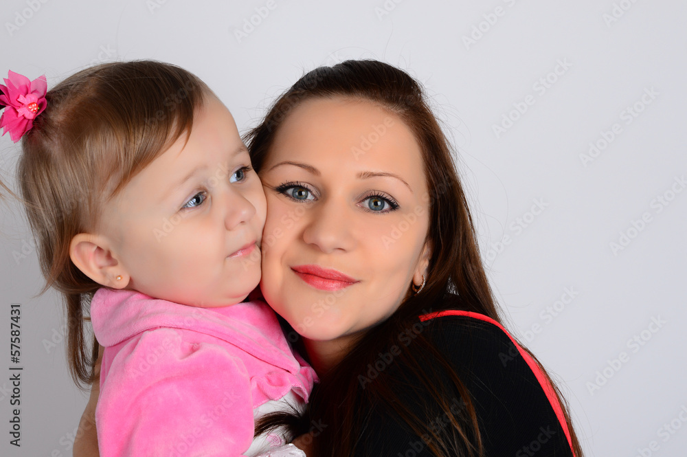 A portrait of a young mother in a red dress holding her small da A portrait of a young mother in a red dress holding her small da