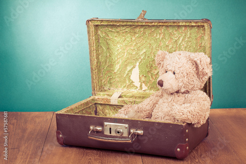 Teddy Bear toy sitting in old retro suitcase photo