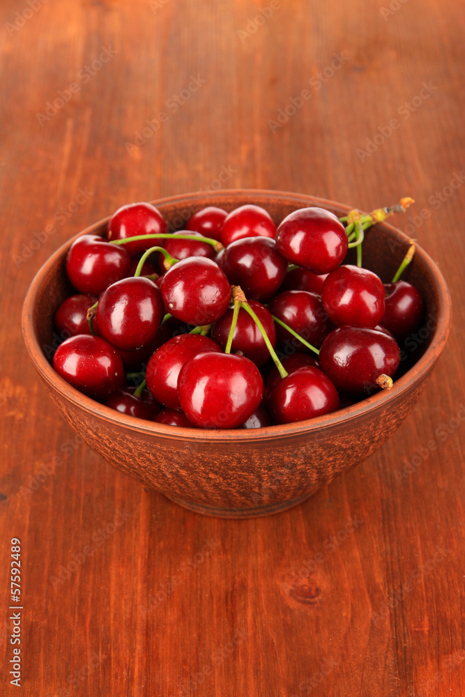 Cherry berries in bowl on wooden table close-up Cherry berries in bowl on wooden table close-up