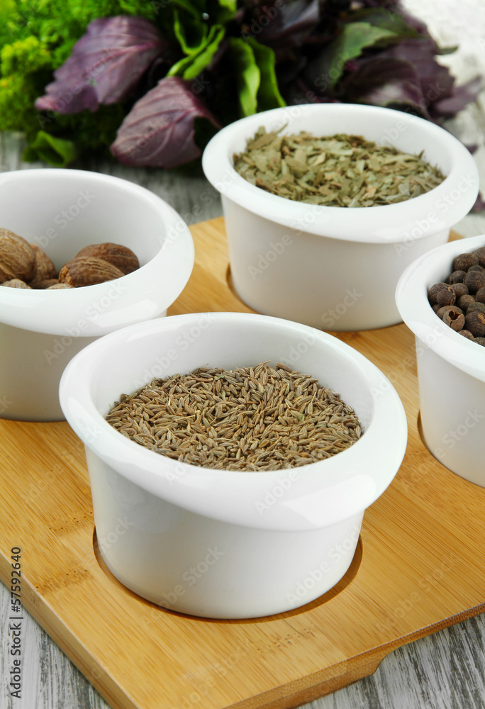 Assortment of spices in white bowls, on wooden background Assortment of spices in white bowls, on wooden background