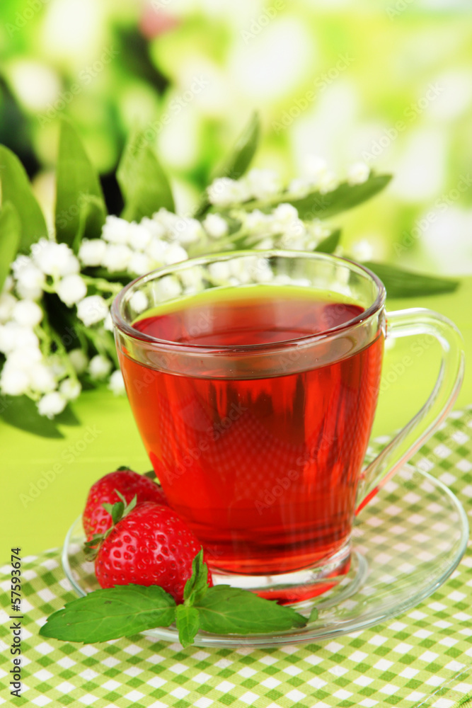 Delicious strawberry tea on table on bright background Delicious strawberry tea on table on bright background