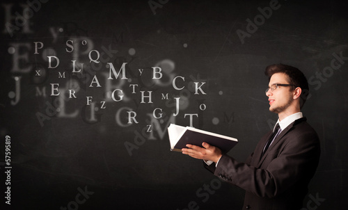 Young man reading a book with alphabet letters