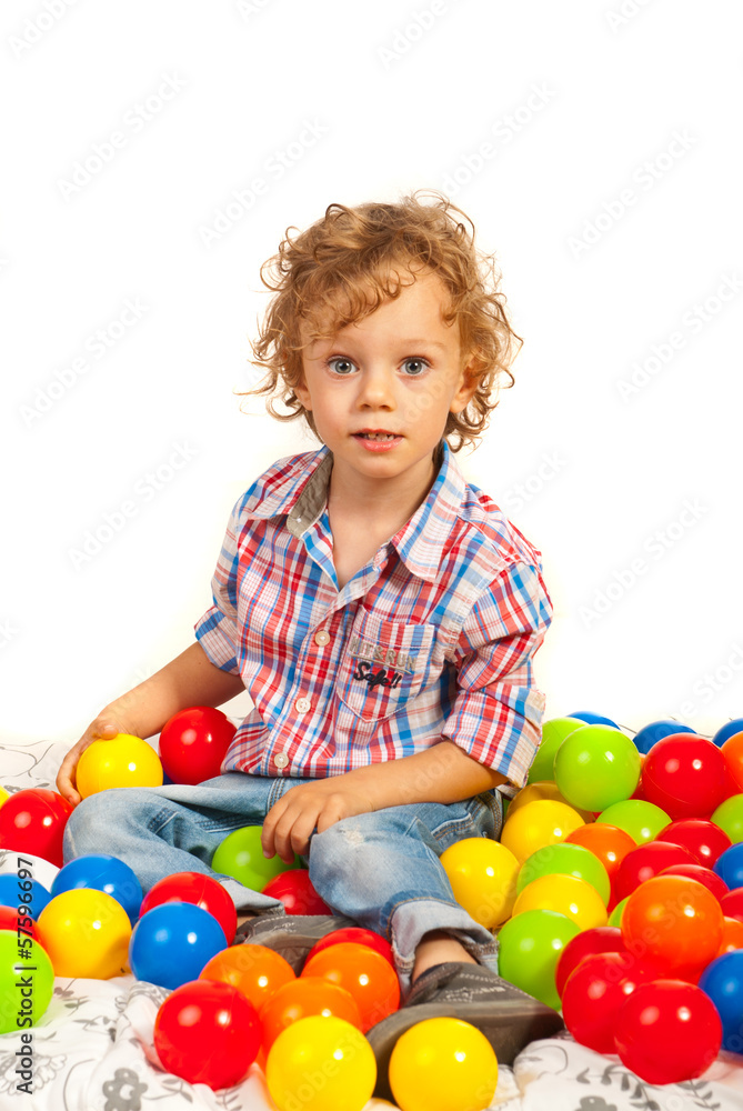 Toddler boy sitting on colorful balls Toddler boy sitting on colorful balls