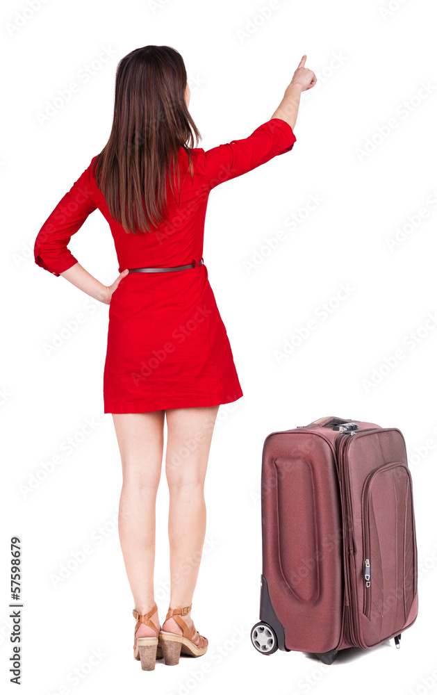 Back view of young brunette woman traveling with suitcas and poi Back view of young brunette woman traveling with suitcas and poi