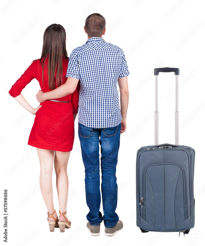 Back view of young couple traveling with suitcas . Back view of young couple traveling with suitcas .