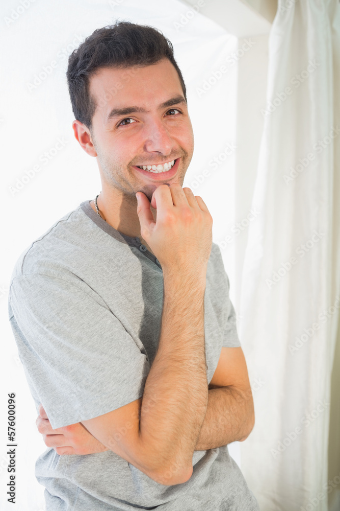 Casual cheerful man looking at camera touching chin Casual cheerful man looking at camera touching chin