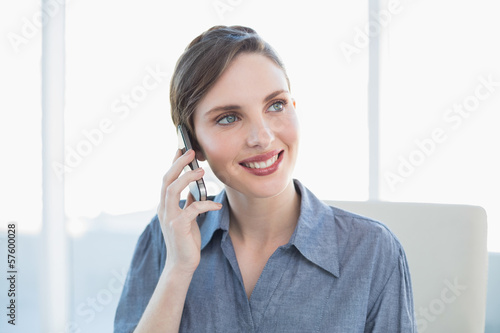 Content lovely businesswoman phoning with her smartphone sitting