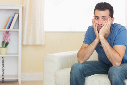 Casual upset man sitting on couch